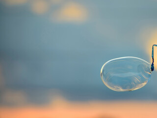 Huge crystal clear bubble is made by a soap bubble wand