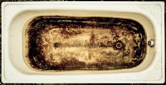 bath tub used more people and with traces of limestone and rust. Broken old abandoned dirty toilet bowl. Grunge bathroom. Dirty Bath. top view.