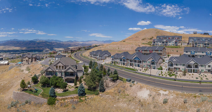 Beautiful houses along roads against blue sky and mountains in Lehi Utah. Aerial landscape of an affluent area known as Silicon Slopes viewed on a sunny day.