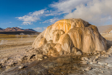 Landscape with steaming travertine mound of the El Tatio geyser on the high altitude plateau of the...