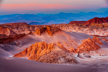 Sunset over the colorful badlands in the Moon Valley (Valle de la Luna) in the arid Atacama desert in the north of Chile - obrazy, fototapety, plakaty