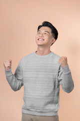 Young handsome man very happy and excited doing winner gesture with arms raised, smiling and screaming for success.