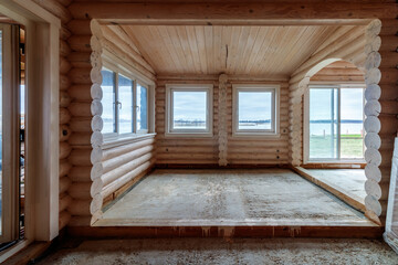 A two-story wooden cottage from the inside out in coniferous spruce pine green forest