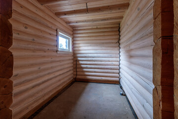 A two-story wooden cottage from the inside out in coniferous spruce pine green forest