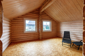A two-story wooden cottage from the inside out in coniferous spruce pine green forest