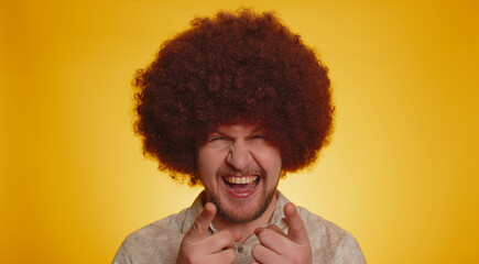 Fototapeta na wymiar Joyful man with lush Afro hairstyle coiffure laughing out loud after hearing ridiculous anecdote, funny joke, feeling carefree amused, positive people lifestyle. Young hipster guy on yellow background