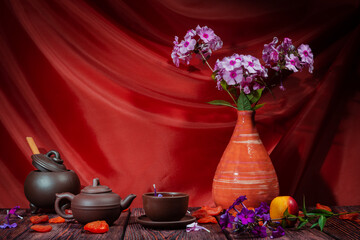 Still life of flowers - summer blooming stems of plants. Draped background - theatrical stage...