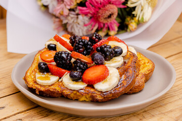 Pan francés fresco, recién hecho con fruta picada, plátanos fresas y zarzamoras. Vista horizontal, con close-up