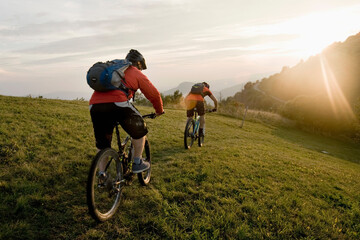 two mountain bikers on the way at sunset, Kolovrat, Istria, Slovenia