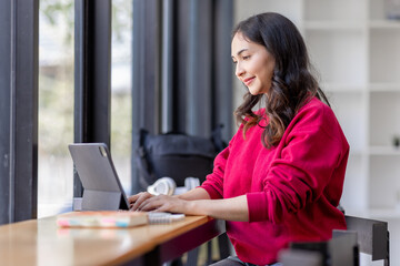 Happy Young Indian Asian Business woman sitting on Digital Tablet work desk Workplace. 