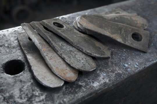 Harvester blades on anvil at blacksmith shop