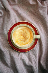 Cup Of Cappuccino Coffee In Bed On Crumpled Sheets