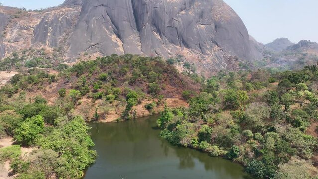 Aerial - Rising reveal wide shot of an inselberg rock