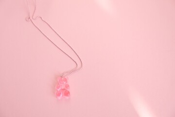 Obraz na płótnie Canvas Children's jewelry in the form of a bear on a pink background. Jewelry, costume jewelry.