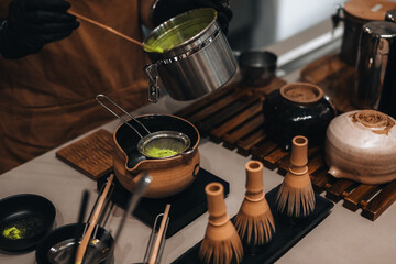 Fototapeta na wymiar Japanese Matcha green tea making process. Traditional utensils made from natural organic materials