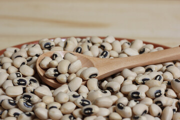 Uncooked Black Eyed Peas in Bowl on Wooden Table