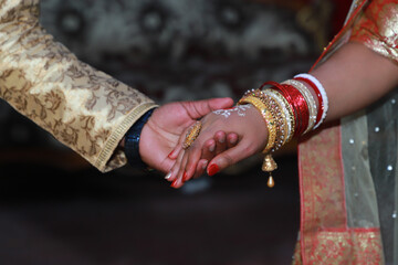 Newly wed indian couple holding each other, close up photo of holding hands 