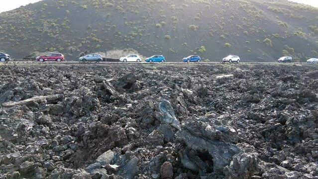 Europe, Spain, Lanzarote,  Canary Islands 2023 - Timanfaya nationl parck is a volcanic biosfera reserve tourist attraction - queue of cars in line traffic car of tourists visiting the amazing nature 
