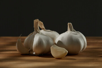 garlic on a cutting board. garlic clove along with whole ones on a dark background. vegetables ready for cutting close-up. kitchen on a sunny day. High quality 4k footage