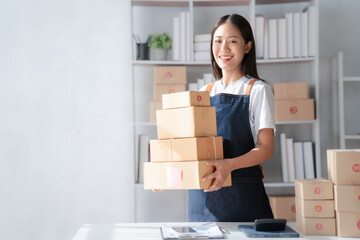 Attractive young mixed race chinese half thai ethnicity SME owners woman entrepreneurs working on receipt box and check online orders, SME home business ideas online.