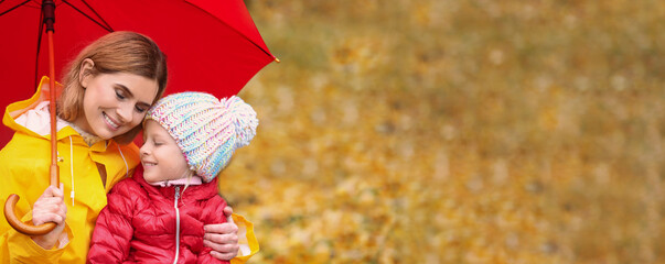 Mother and daughter with umbrella in autumn park on rainy day, space for text. Banner design