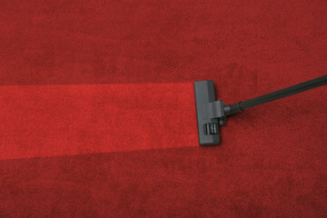 Vacuuming dirty red carpet. Clean area after using device, top view