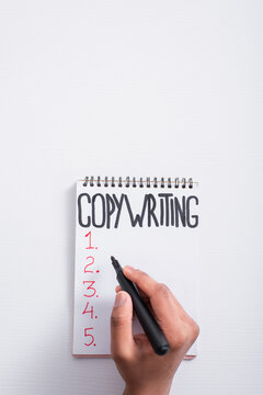 Top view of man holding marker near notebook with copywriting lettering on table.