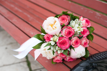 the bride's bouquet on a bench in the park