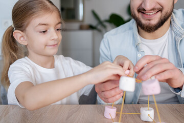 Child girl with father make model of molecule at home. child learning chemistry, engineering and STEM.