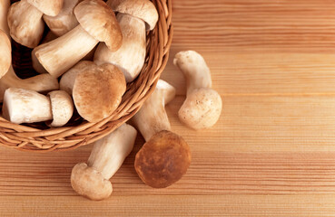 raw white mushrooms in basket on wooden table.