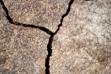 Abstract natural background from a close-up of a cracked rye bread crust. Selective focus. Space for lettering and design.