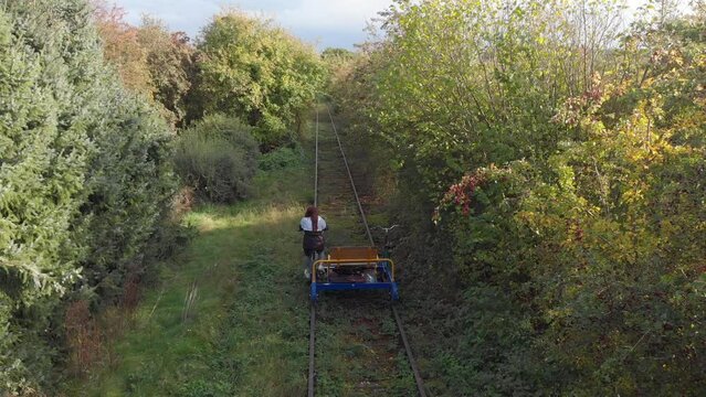 A person using a draisine alone some abandoned train tracks in Germany