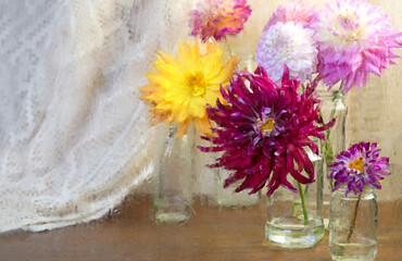 Dahlias in glasses on a wooden table. View through wet rainy windowPInk white Dahlia flowers, top view. Colorful dahlia flowers mix wallpaper background.
