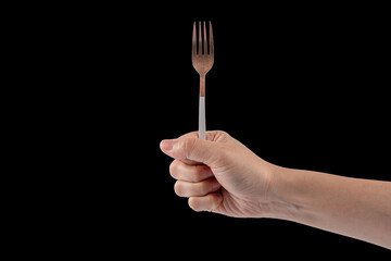 Hand and metal white fork on black background.