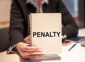 The hand holding the word penalty on a white notepad. Business concept - obrazy, fototapety, plakaty