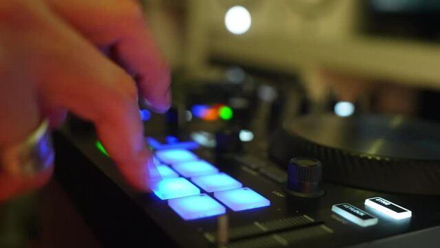 Closeup of a man making music beats and sounds with a drum pad neon light machine. High quality 4k footage