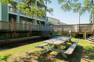 Navarre, Florida- Wood dining table with seats outside the buildings near the creek. Picnic area under the shade of the tree near the bay.