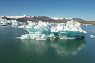 blue iceberg floating over glacier lake