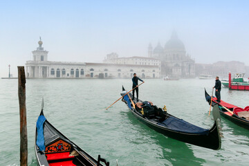 Fototapeta na wymiar Venezia. Gondole in Canal Grande verso la Dogana e La Salute con foschia
