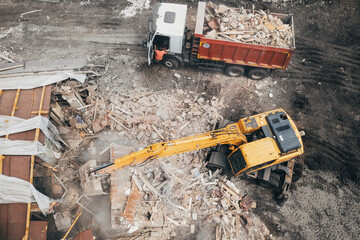 Demolition of building, aerial top view from drone. Excavator breaks old house. Freeing up space...
