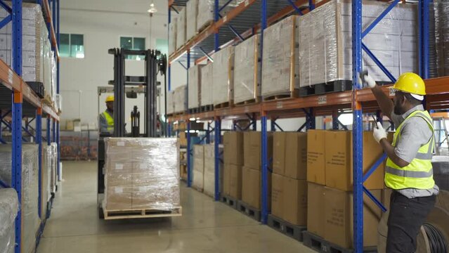 Teamwork of black workers working in large warehouse store industry.Rack of stock storage. Interior of cargo in ecommerce and logistic concept. Depot. People lifestyle. Shipment service for container