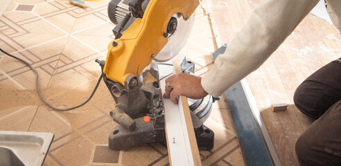 Fototapeta na wymiar Worker cutting part of furniture with cutting machine.
