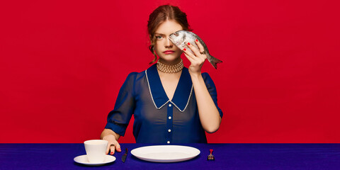 New vision. Young extravagant woman with cup of coffee and raw fish on bright red background....