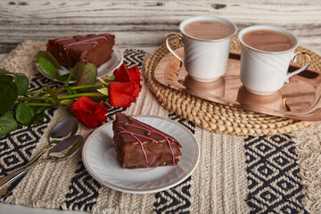 Aesthetic breakfast with chocolate cherry cake pieces, coffee cups, red roses and St Valentines day