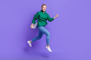 Fototapeta na wymiar Full length photo of pretty sweet lady wear green sweater running jumping holding gadget isolated violet color background