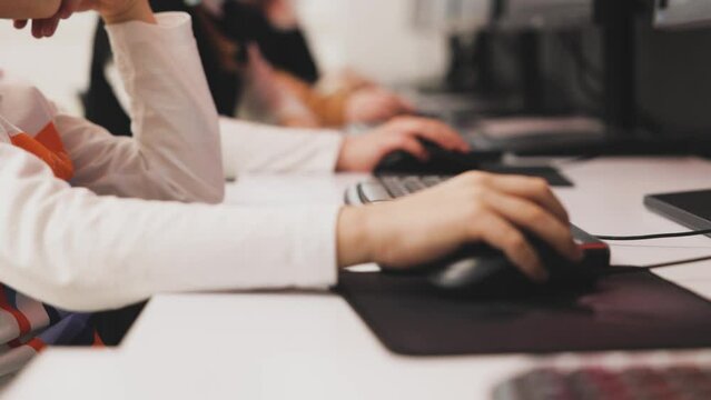 Children Learning To Use Computer. Close Up View Of Many Hands On PC Mouse. Goes From Mouse And Keyboard. Focus Moves From Hand To Hand