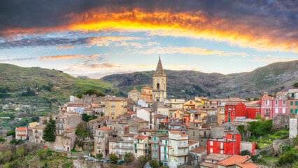 Fototapeta na wymiar Amazing Panorama of the belltower and the village in the valley at sunset