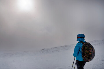 Tourist in a mountainous area in winter during a snow storm. Extreme winter vacation. The majesty...