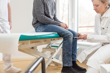 female doctor with a reflex hammer in a treatment room