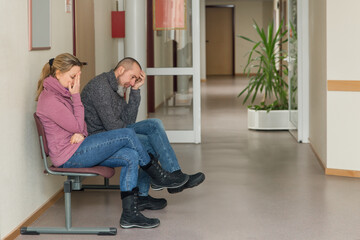 two patients sitting in the waiting room of a doctor's office